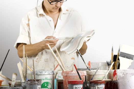 Picture of a potter painting a clay piece