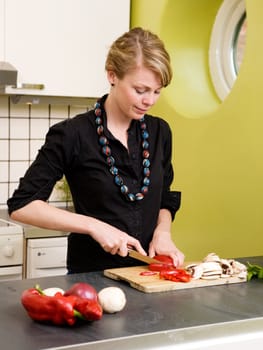 A woman cutting vegetables at home on the counter