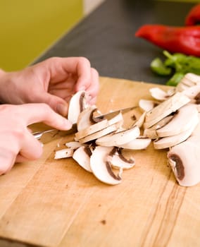 A woman cutting mushrooms at home on the counter