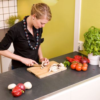 A woman cutting vegetables at home on the counter