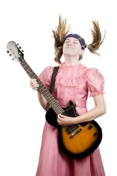 Young girl in a pink dress head-banging with an electric rock guitar