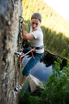 A climber at the top of a ledge looking down with fear.