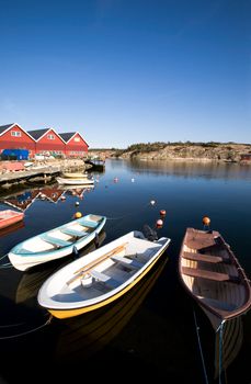 A group of small row boats tied to the dock 