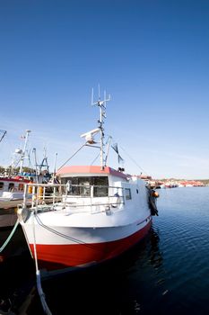 A number of fishing boats sit at dock on a warm summer day.