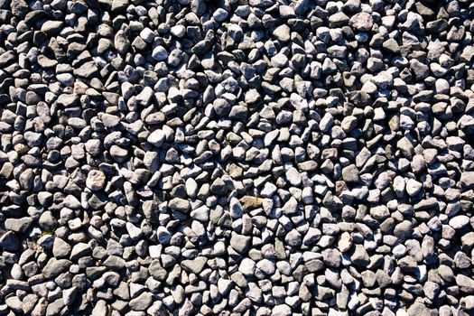 A small stone background texture of smooth stones near the ocean.