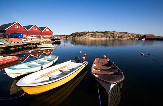 A group of small row boats tied to the dock 