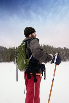 A confident cross country skiier out on a refreshing trip over a frozen lake with a backpack