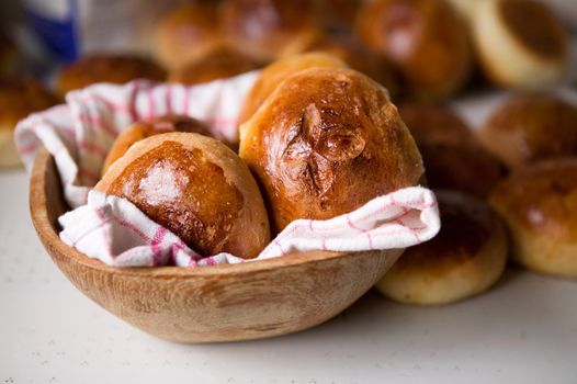 Close up detail of freshly baked hot cross buns in romantic renaissance lighting and a shallow depth of field.