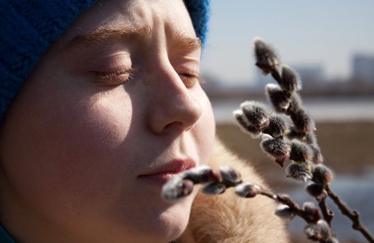 Spring has come to Moscow. Young woman look at branches of tree.