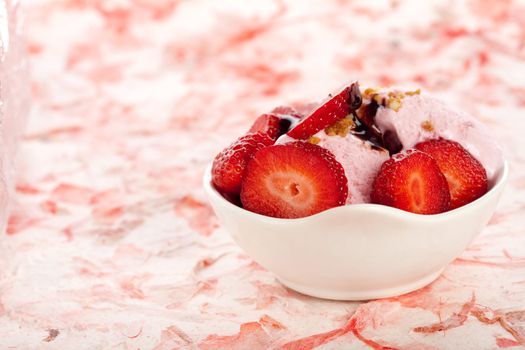 Strawberry icecream with fresh strawberries on pink background