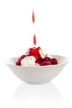 Delicious vanilla icecream with raspberries and strawberry sauce