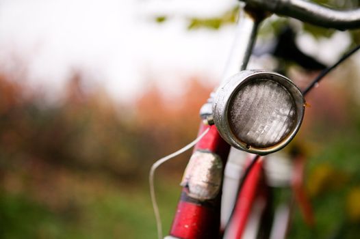 An old red bike detail with a shallow depth of field on a rainy autumn day.