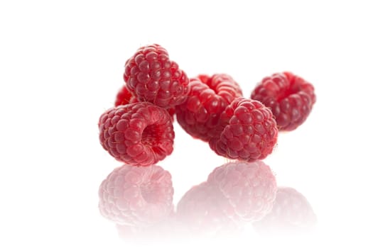 Delicious raspberries with reflection on white background