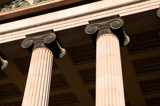 A detail of an old building built in the old Greek style with Ionic columns.