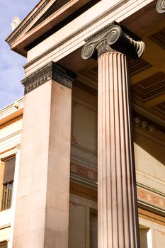 A detail of an old building built in the old Greek style with Ionic columns.