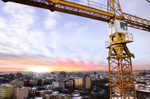 A detail of a crane overlooking the Oslo fjord and city of Oslo.