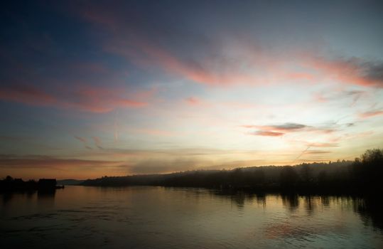 A river near the ocean at sunset with fog and mist.