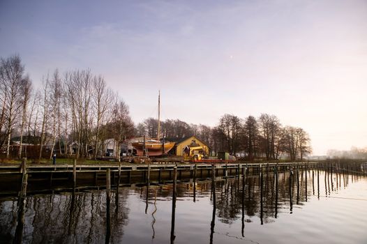 A boat harbor in the late fall painted in the evening light of sunset