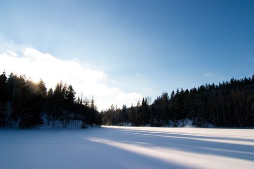 A frozen lake in the middle of winter on a beautfil blue sky day.