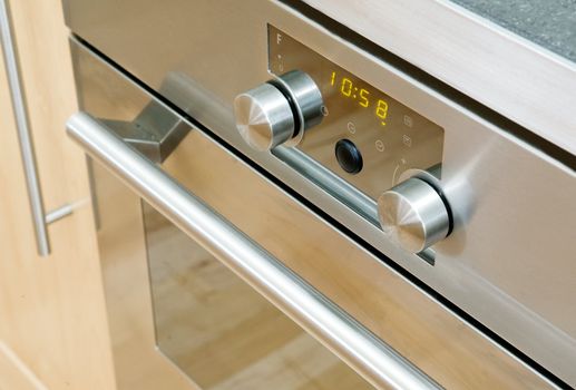 A modern stainless steel oven detail showing the knobs and door