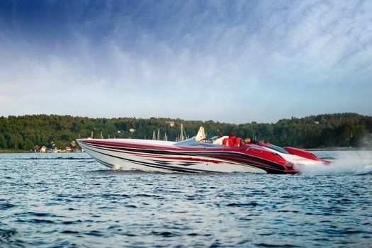 A very large speedboat crusing on a lake.