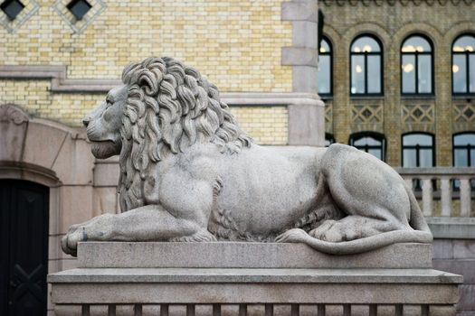 A lion statue sits majesticaly on it's pedestal.