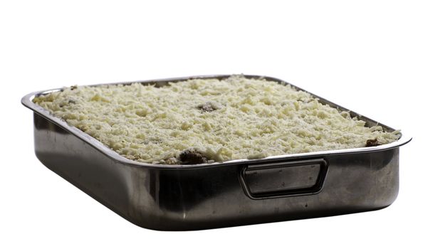 Homemade lasagna in a metal dish, isolated against a white background
