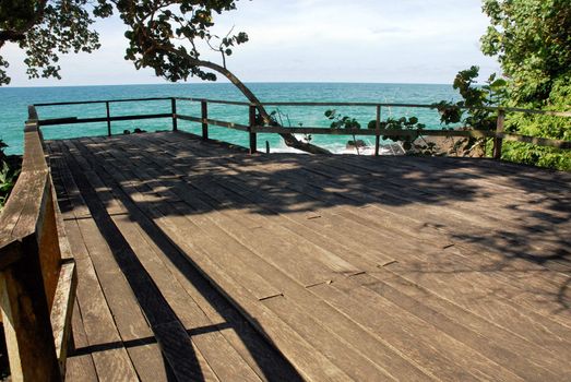 Wooden deck over the sea sorrounded of vegetation
