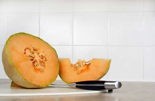 cantaloupe on a cutting board with knife