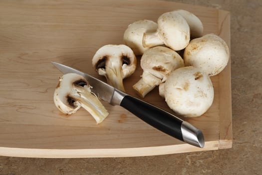 mushroom with knige on wood cutting board