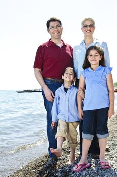 Happy family standing on shore at the beach