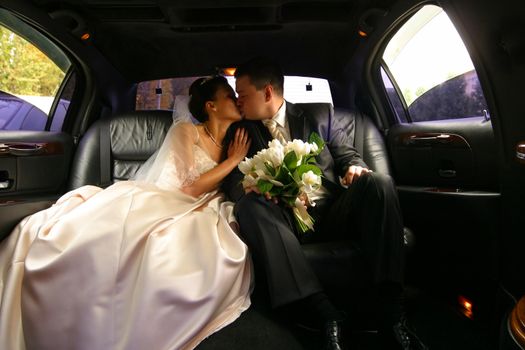 Kiss of a newly-married couple in car