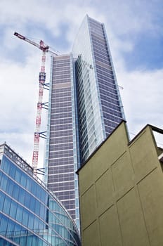 A brand new modern skyscraper with the urban contrast of an old house