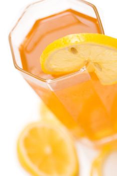 A glass full of iced tea with a lemon slice