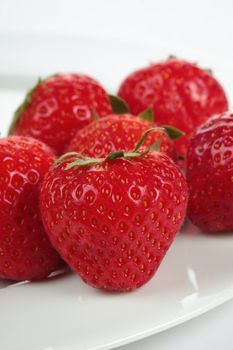 a bunch of strawberries on a plate over white background