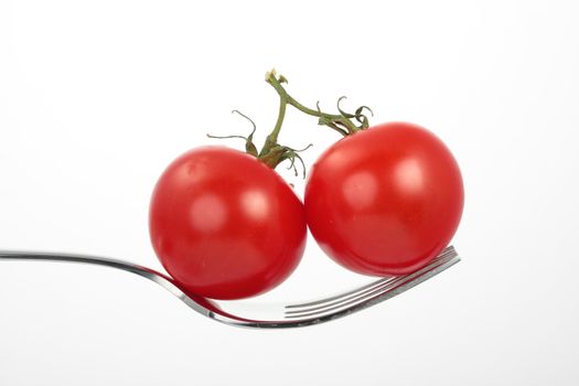 two tomatoes on a fork