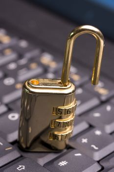 a golden padlock on a black notebook keyboard