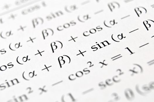 Close up of a textbook with algebra formulas and problems.