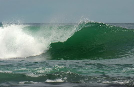 Big wave breaks in ocean. Surfers perspective