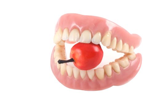 Dentures with little fake apple, isolated on a white background.