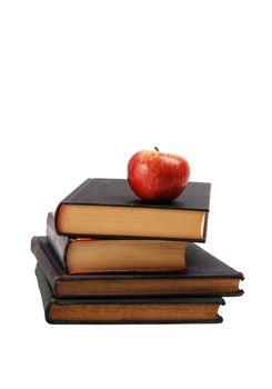 Ripe red apple on a book pile. Isolated on white background