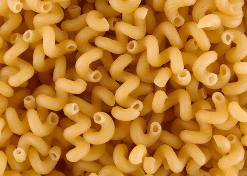 Texture consisting of dry macaroni on a plate surface