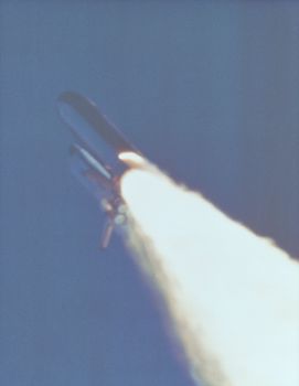 At 58.778 seconds into powered flight, a large flame plume is visible just above the SRB exhaust nozzle indicating a breach in the motor casing. Photo taken: 01/28/1986. ** Credit: NASA / yaymicro.com **