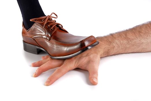 Foot wearing a formal shoe crushes a male hand. White Background