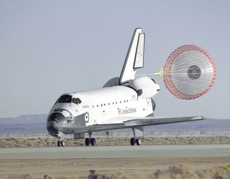 The Space Shuttle Atlantis lands with its drag chute deployed on runway 22 at Edwards, California, to complete the STS-66 mission dedicated to the third flight of the Atmospheric Laboratory for Applications and Science-3 (ATLAS-3), part of NASA's Mission to Planet Earth program. Photo taken: 11/14/1994. ** Credit: NASA / yaymicro.com **