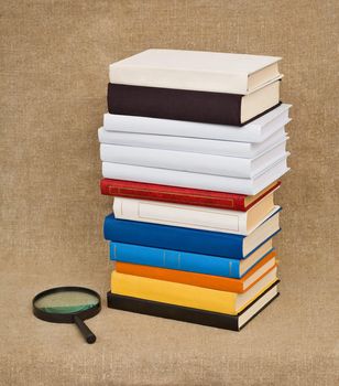 A high pile of books and magnifying glass - Educational still life
