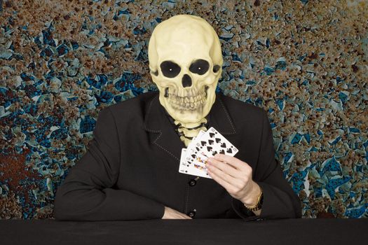 Horrible cardsharper in a mask - the skull sitting at the table