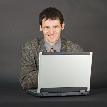 A young man with a computer on a dark background