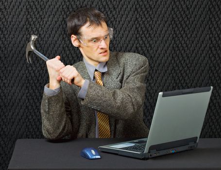 Comical person intends to break the computer with a hammer