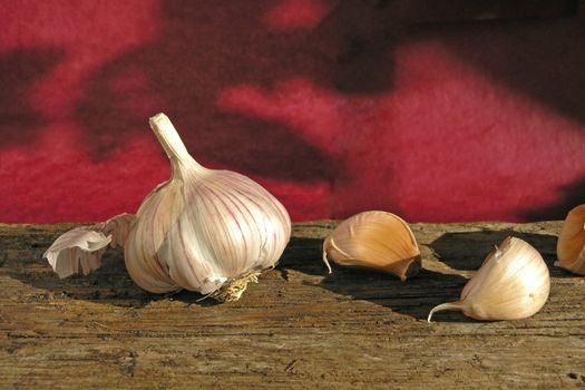 garlic on wood table (dark red background)